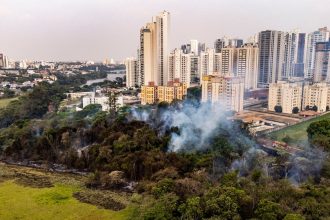 Vista aérea de um incêndio florestal próximo a áreas urbanizadas em Londrina, no Paraná.
