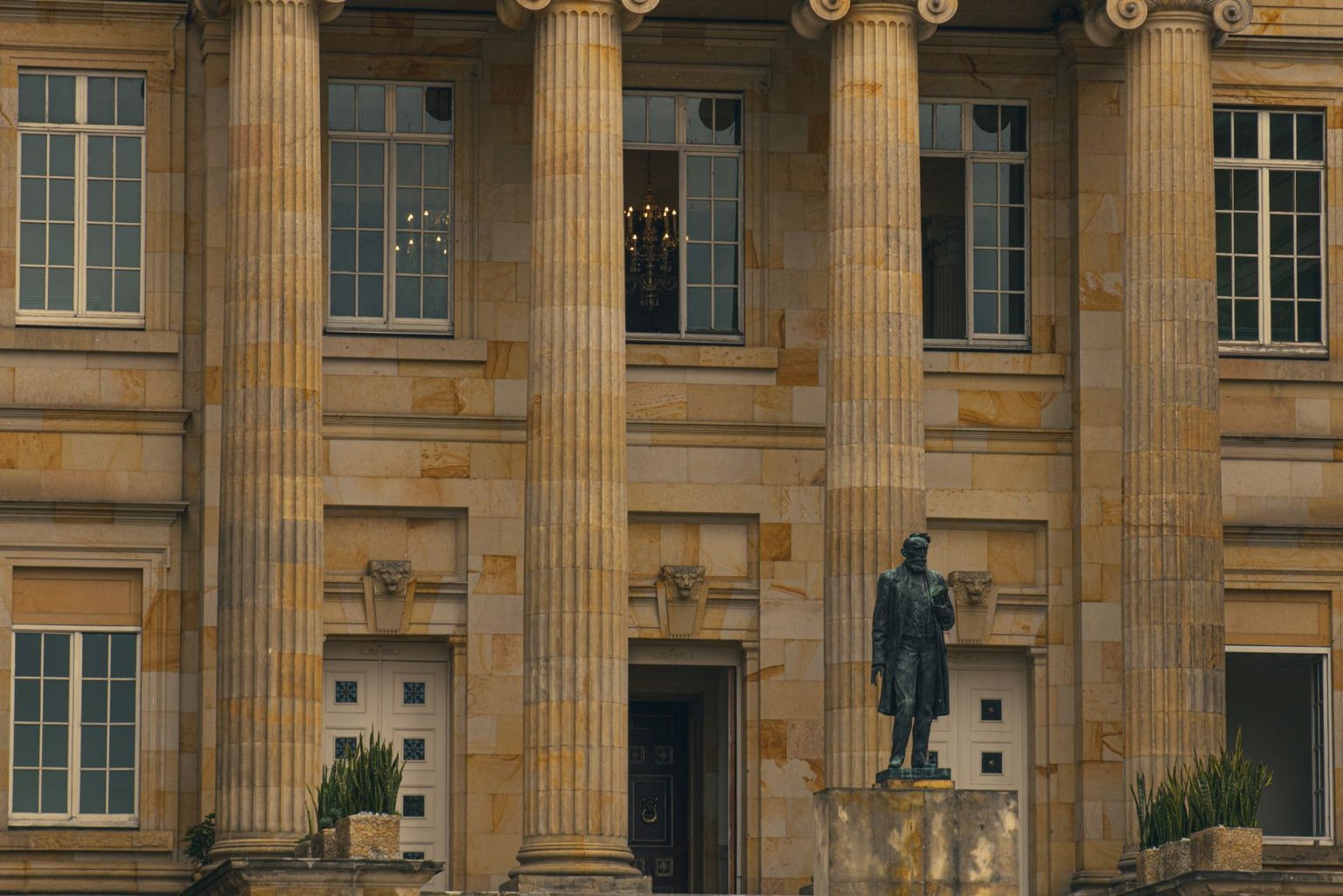 Fachada de um prédio de tribunal, com colunas e uma estátua na entrada.