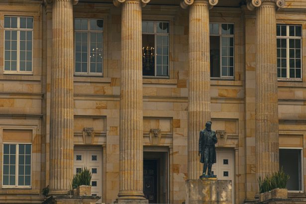 Fachada de um prédio de tribunal, com colunas e uma estátua na entrada.